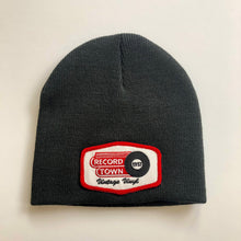 Load image into Gallery viewer, Black knit beanie style cap with embroidered Record Town patch on the front.