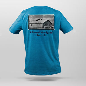 Back view of bright blue t-shirt with Bluebird Nightclub photograph graphic and the quote "I like music when I party!" from house band leader Robert Ealey.